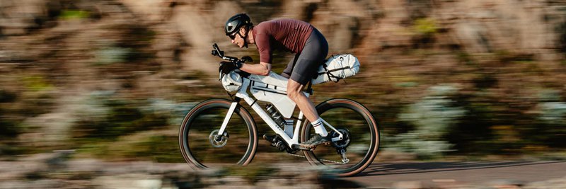Das Foto zeigt einen Mann auf seinem Gravel Bike an dem ein ein komplettes Cyclite Taschen Set angebracht ist.