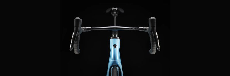 Das Foto zeigt ein von vorne fotografiertes hellblaues Trek Madone Performance Rennrad vor schwarzem Hintergrund.