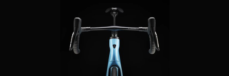 Das Foto zeigt ein von vorne fotografiertes hellblaues Trek Madone Performance Rennrad vor schwarzem Hintergrund.